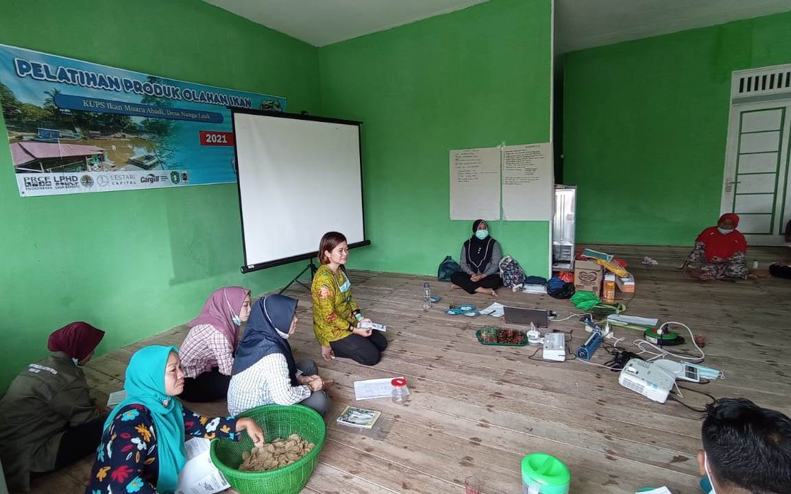Aries Nursejari dari Dinas Perikanan Kapuas Hulu sedang melatih pembuatan kerupuk kering