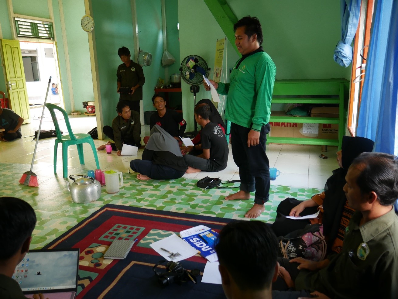 Seorang peserta sedang diajarkan cara mengambil foto dalam praktik pelatihan jurnalistik dan fotografi di Desa Penepian Raya